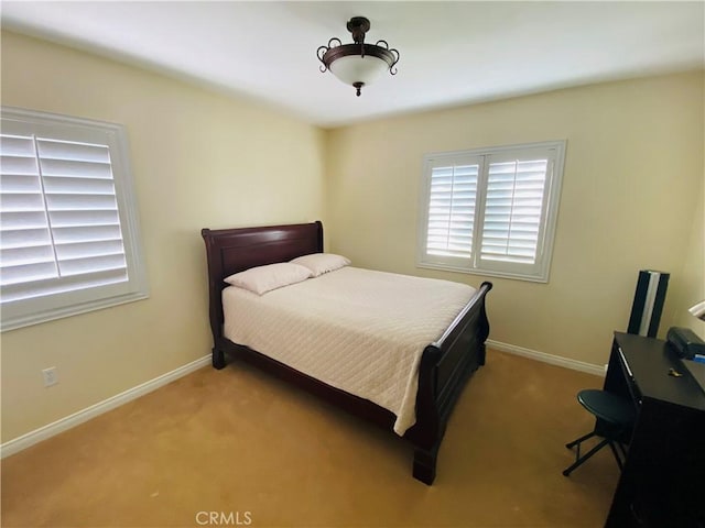 bedroom featuring baseboards and light colored carpet