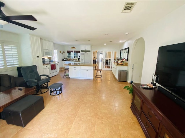 living area featuring visible vents and a ceiling fan