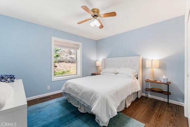 bedroom with wood finished floors, ceiling fan, baseboards, and visible vents