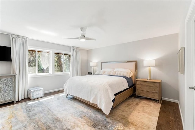 bedroom featuring ceiling fan, baseboards, and wood finished floors
