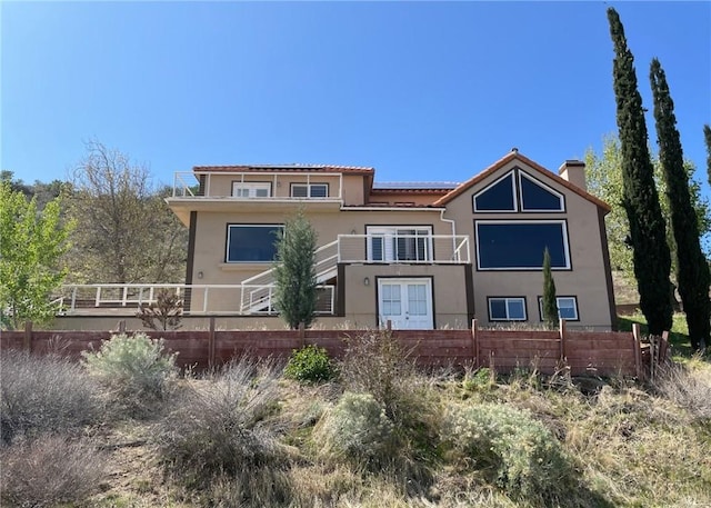 exterior space featuring stucco siding, fence, and a balcony