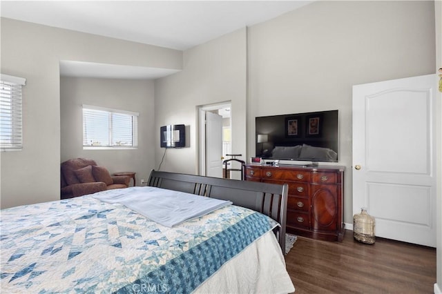 bedroom featuring dark wood-style floors and vaulted ceiling