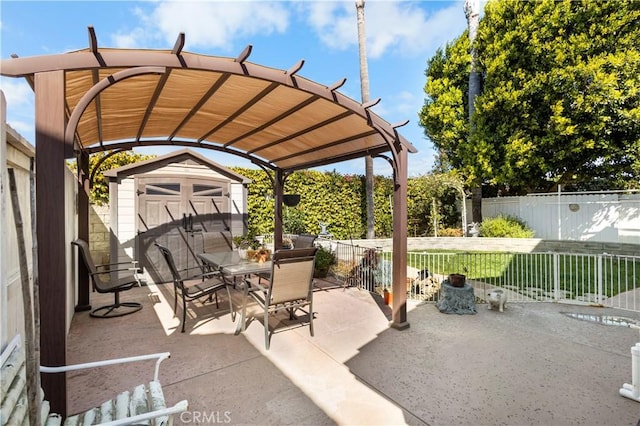 view of patio / terrace featuring a storage shed, an outbuilding, a fenced backyard, and outdoor dining space