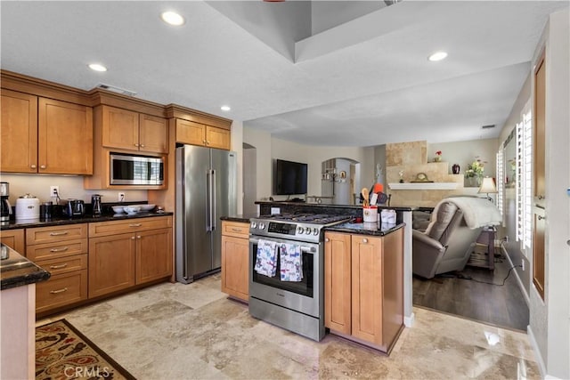 kitchen with a center island, open floor plan, appliances with stainless steel finishes, brown cabinets, and recessed lighting