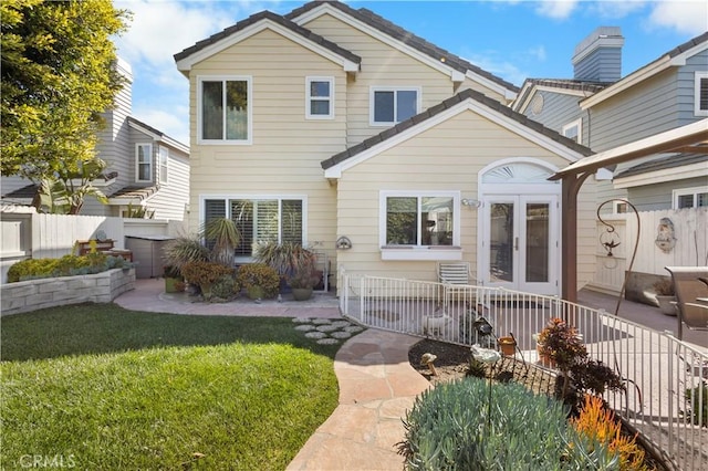 back of property featuring a patio area, french doors, fence, and a lawn