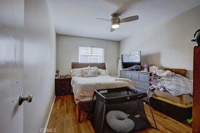 bedroom featuring baseboards, a ceiling fan, and wood finished floors