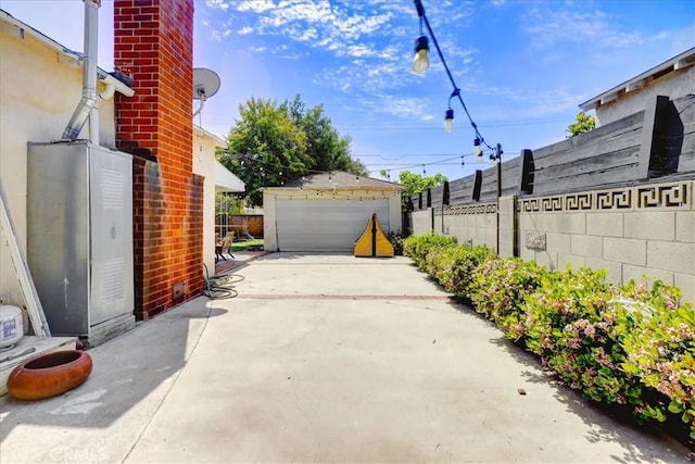 view of patio / terrace featuring an outdoor structure, a detached garage, and fence
