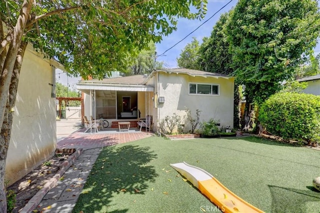 rear view of house with a patio area and stucco siding