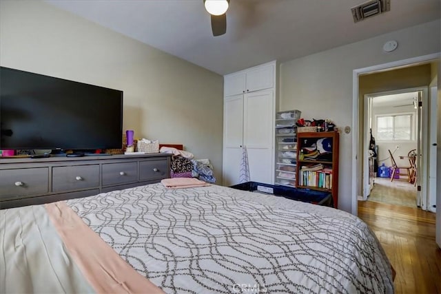 bedroom featuring a closet, visible vents, ceiling fan, and wood finished floors