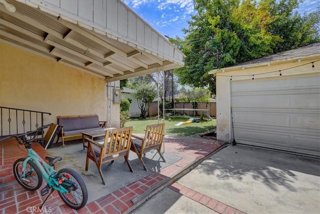 view of patio with an outbuilding, fence, a garage, and an outdoor hangout area