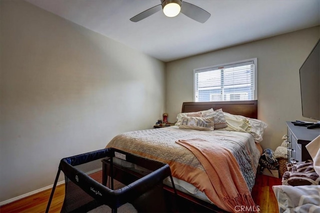 bedroom with wood finished floors, baseboards, and a ceiling fan