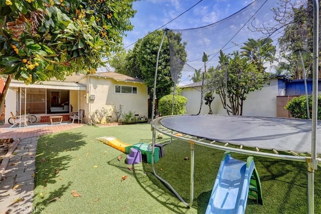view of yard featuring a trampoline and a patio area