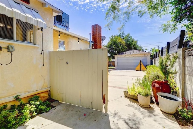 view of yard featuring an outbuilding, fence, and a gate