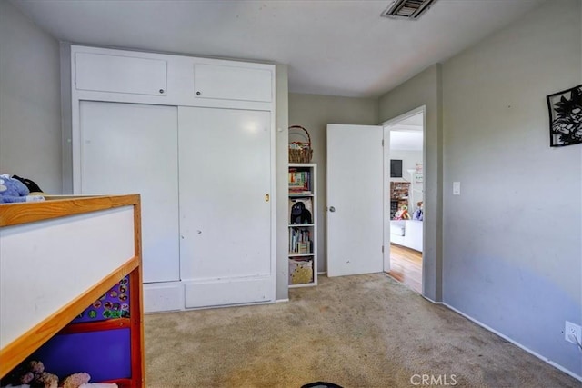 bedroom with carpet, visible vents, and a closet