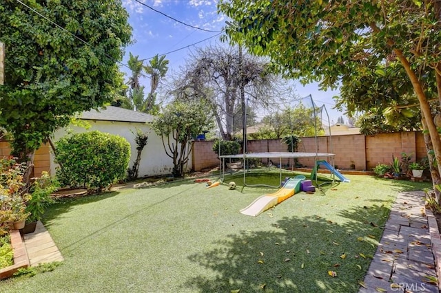 view of yard featuring a fenced backyard and a trampoline