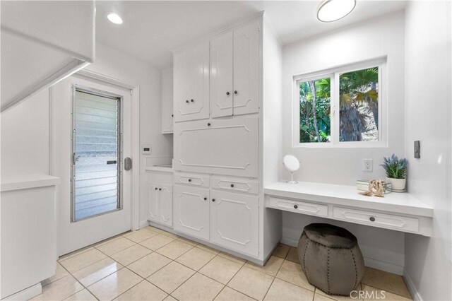 950 S Spring Meadow Dr, West Covina, CA 91791 - laundry area with light tile patterned flooring and a desk