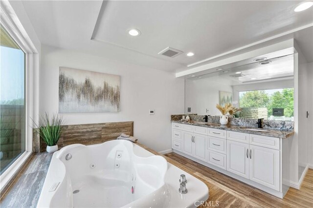 950 S Spring Meadow Dr, West Covina, CA 91791 - full bath featuring wood finished floors, double vanity, a jetted tub, recessed lighting, and baseboards