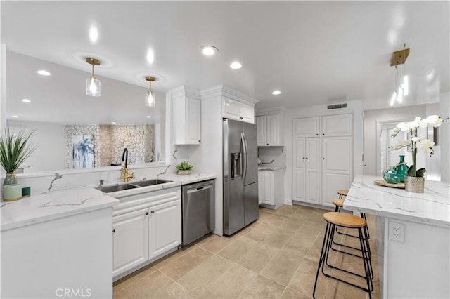 950 S Spring Meadow Dr, West Covina, CA 91791 - kitchen with appliances with stainless steel finishes, a sink, white cabinets, light stone countertops, and decorative light fixtures