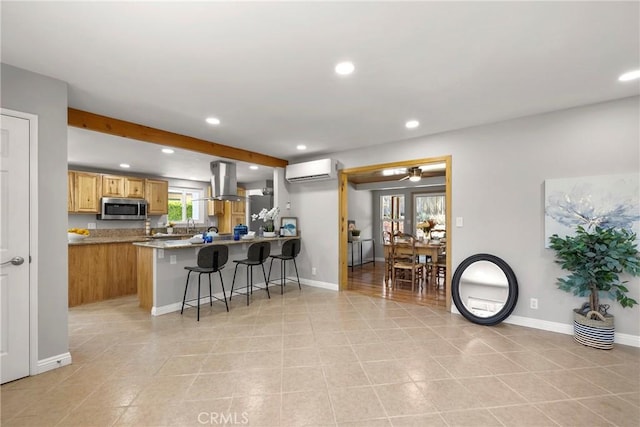 kitchen featuring an AC wall unit, island exhaust hood, stainless steel microwave, a peninsula, and recessed lighting