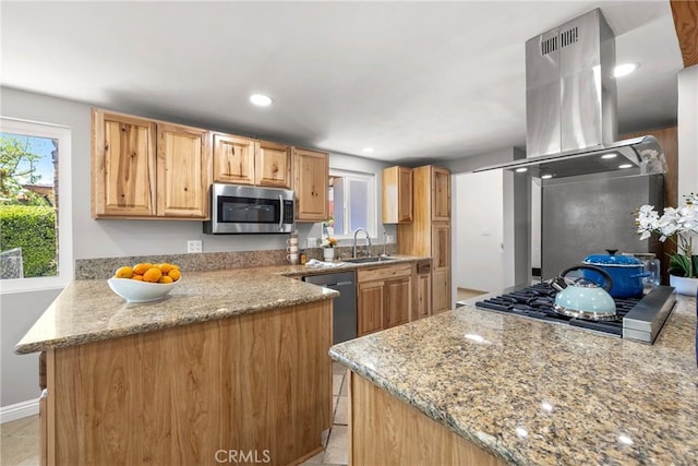 kitchen with light stone counters, a sink, island exhaust hood, stainless steel appliances, and recessed lighting