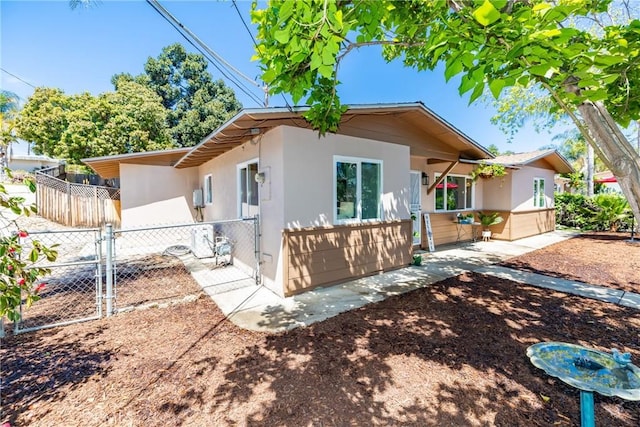 exterior space with a gate, stucco siding, a patio, and fence