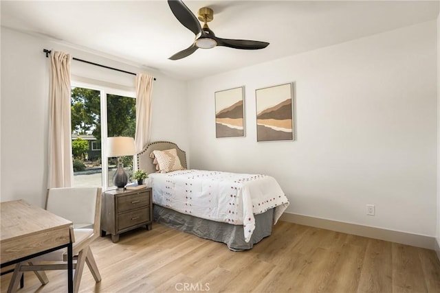 bedroom with light wood-style floors, baseboards, and ceiling fan