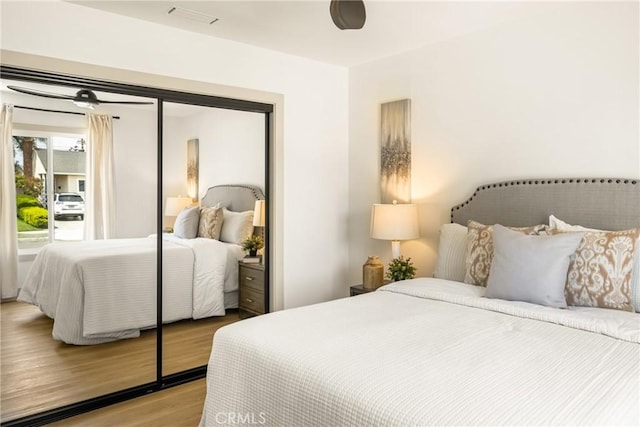 bedroom featuring access to outside, wood finished floors, and visible vents
