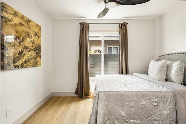 bedroom with a ceiling fan, baseboards, and light wood-style floors