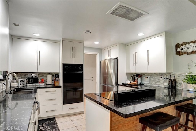 kitchen featuring backsplash, visible vents, a sink, and black appliances