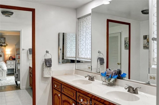 bathroom with connected bathroom, tile patterned flooring, a sink, and double vanity