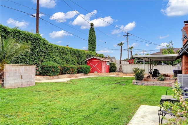 view of yard featuring a fenced backyard, a storage unit, an outdoor structure, and a patio