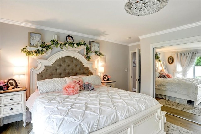 bedroom featuring ornamental molding, wood finished floors, and a closet