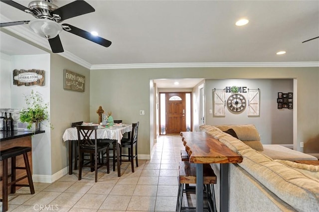dining space with baseboards, ornamental molding, and light tile patterned floors