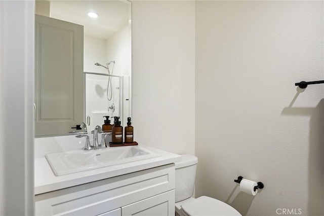 bathroom with toilet, vanity, and walk in shower