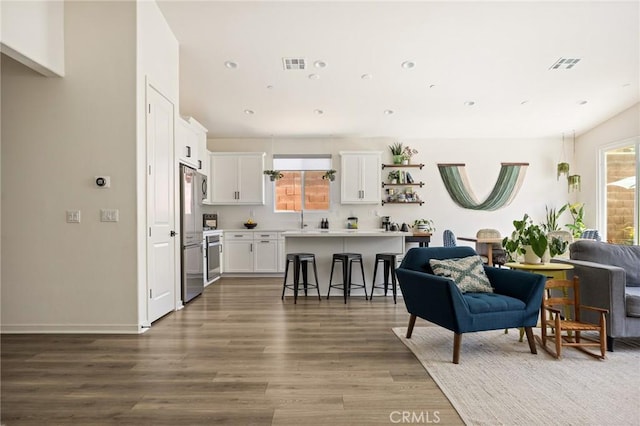 living room featuring plenty of natural light, visible vents, and wood finished floors