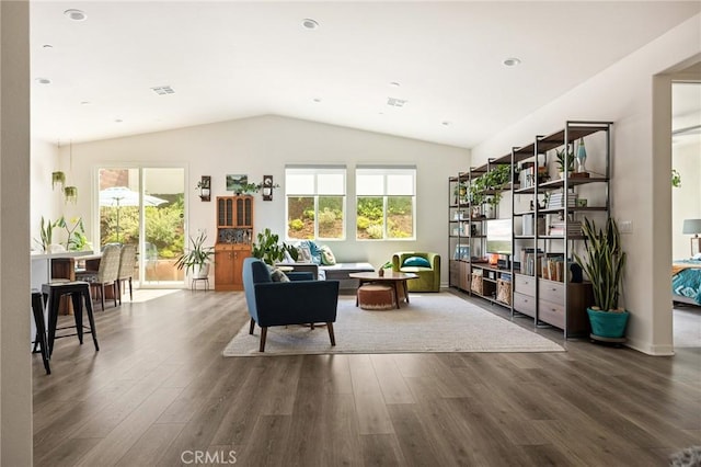 sitting room with wood finished floors, visible vents, vaulted ceiling, and a healthy amount of sunlight