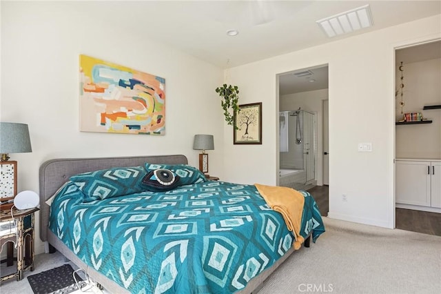 carpeted bedroom with baseboards, visible vents, and connected bathroom