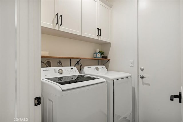 laundry area featuring separate washer and dryer and cabinet space