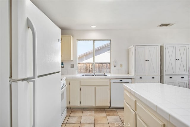 27304 Mystical Springs Dr, Corona, CA 92883 - kitchen with white appliances, a sink, tile counters, cream cabinetry, and recessed lighting