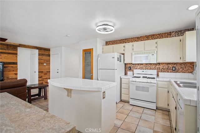 27304 Mystical Springs Dr, Corona, CA 92883 - kitchen with white appliances, tile countertops, wood walls, decorative backsplash, and a kitchen island