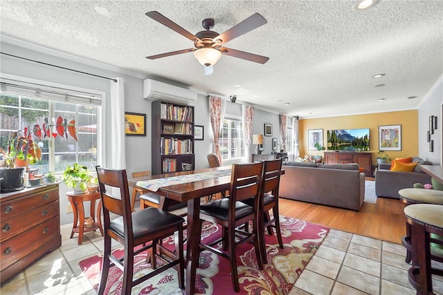dining space featuring a textured ceiling, a wall mounted air conditioner, a ceiling fan, and light tile patterned floors