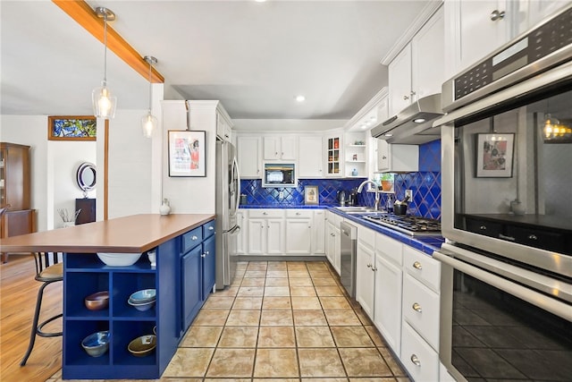 kitchen featuring stainless steel appliances, under cabinet range hood, open shelves, white cabinets, and blue cabinets