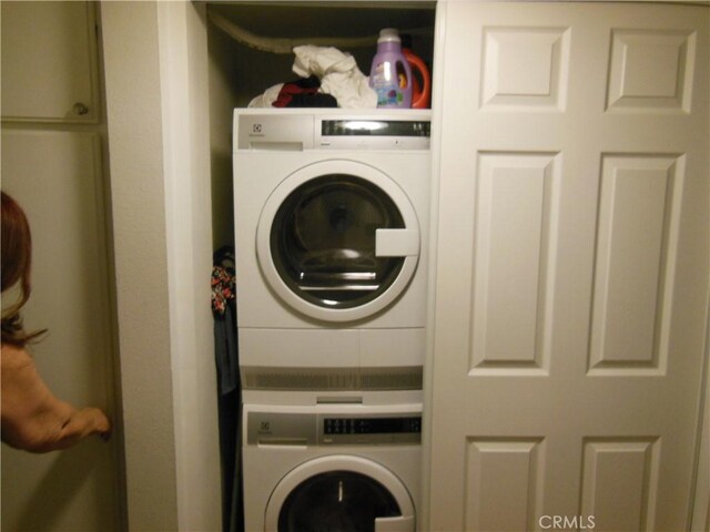 laundry room featuring laundry area and stacked washer and clothes dryer