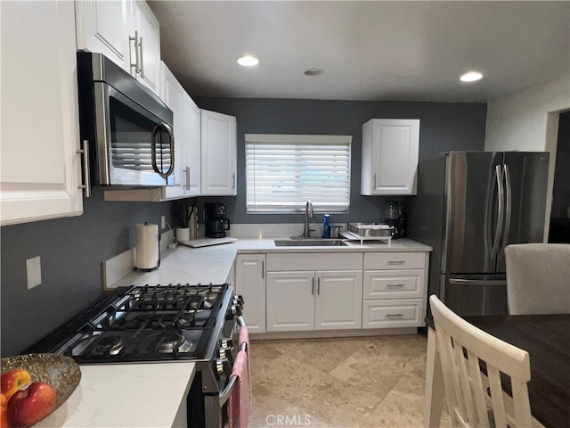 kitchen featuring a sink, light countertops, white cabinets, and stainless steel appliances