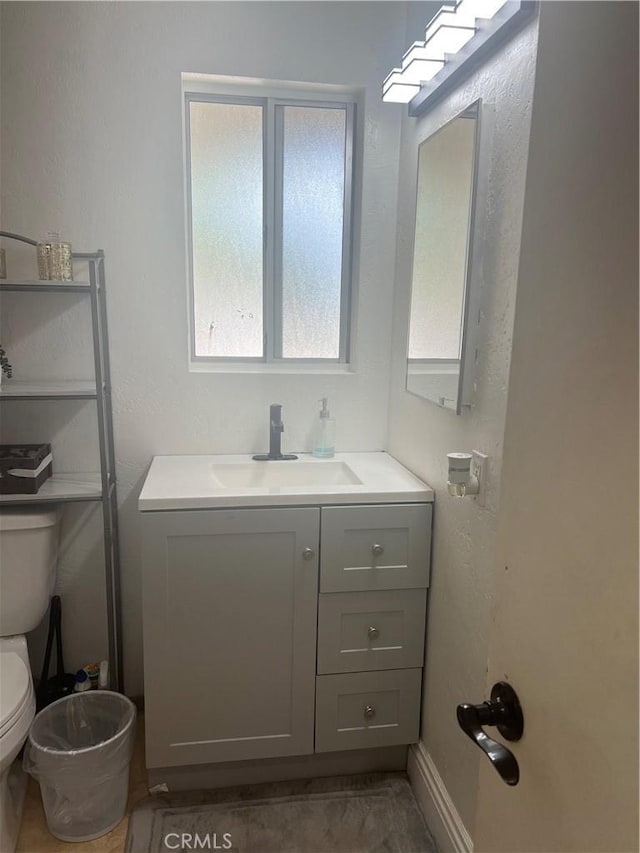 half bathroom featuring vanity and toilet