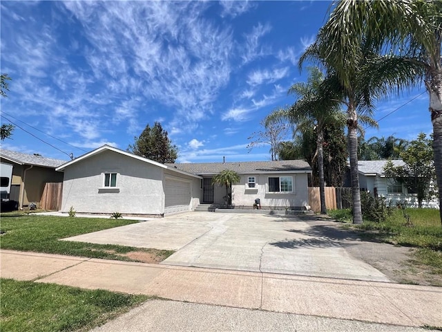 ranch-style home featuring a garage, stucco siding, fence, a front lawn, and concrete driveway