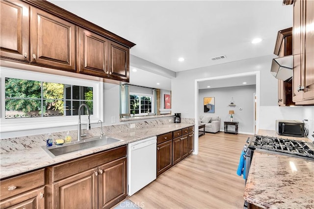 kitchen with light wood-style floors, visible vents, gas range, dishwasher, and a sink