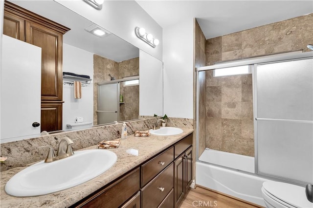 full bath featuring double vanity, a sink, and toilet