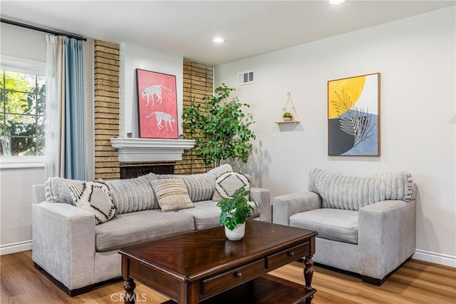 living room featuring recessed lighting, visible vents, baseboards, and wood finished floors