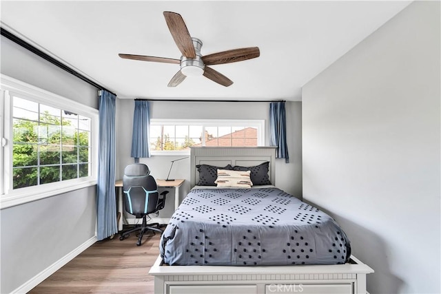 bedroom featuring wood finished floors, baseboards, and a ceiling fan